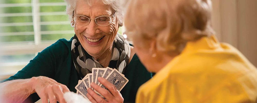 Residents enjoying a card game in a cozy indoor setting
