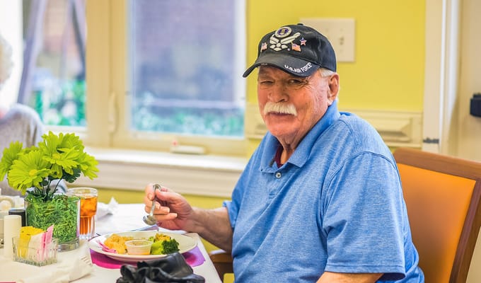 A resident enjoying a meal in a dining area