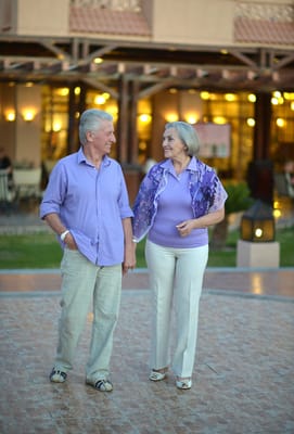 Elderly couple walking together in an outdoor space