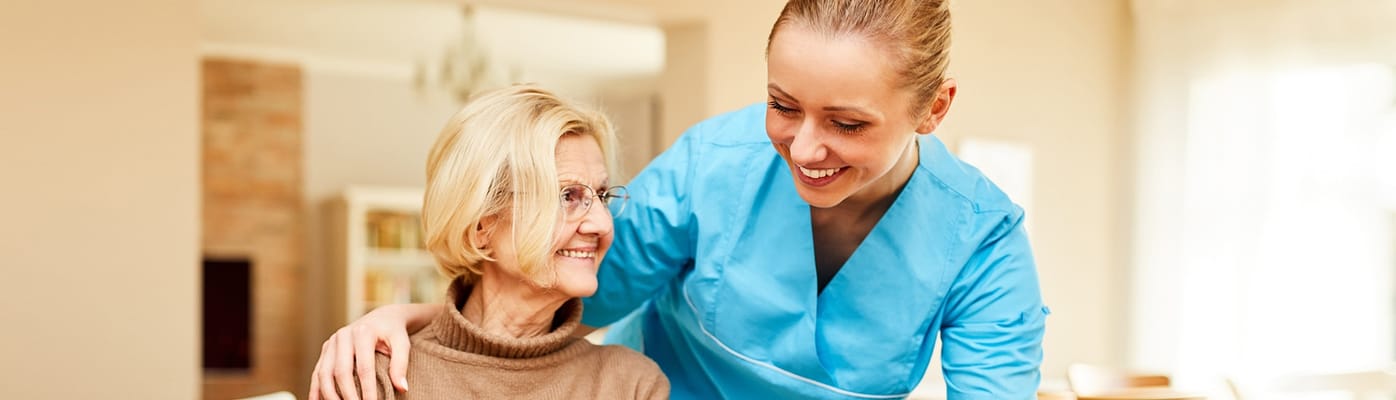 Nurse interacting with an elderly resident in a cozy interior