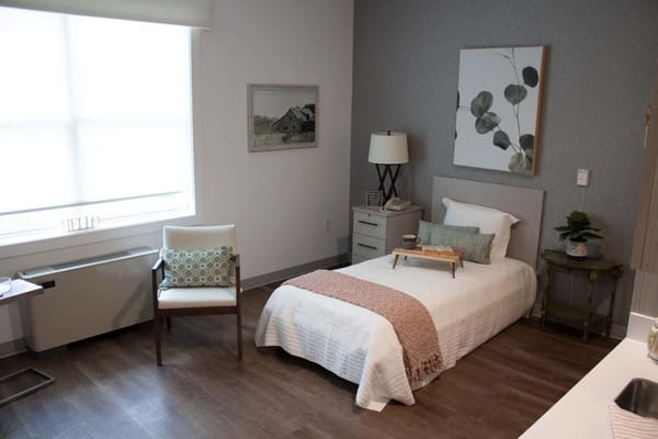 Well-decorated resident bedroom with a bed and chair