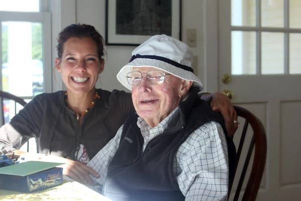 A smiling caregiver with an elderly resident indoors