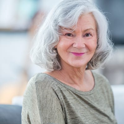 A senior woman smiling warmly at the camera