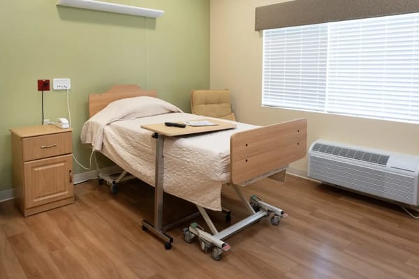 A private resident room with a bed and seating area
