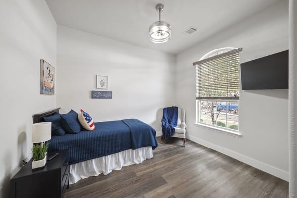 Private resident room with a bed and a chair