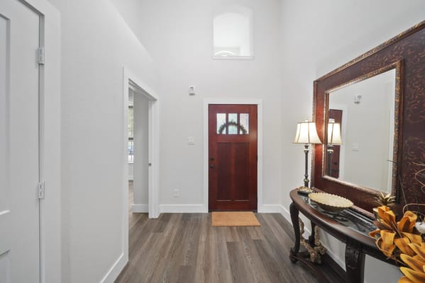 Interior hallway with a front door and mirror