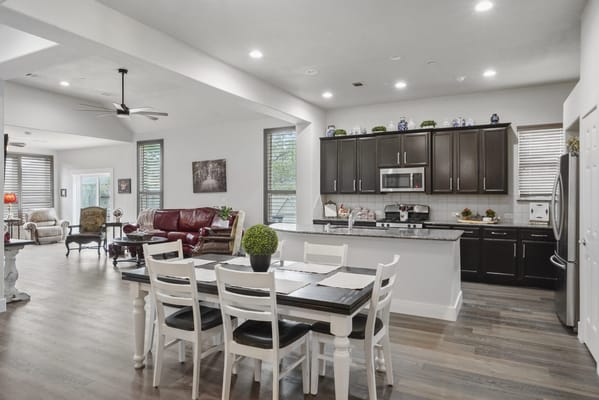 Bright, spacious common area with dining table and seating