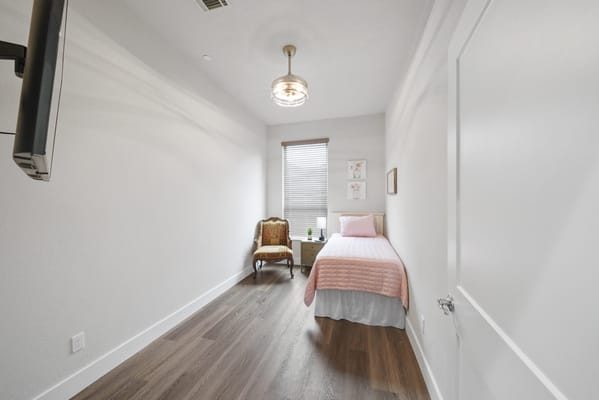 Cozy private room with a bed and chair