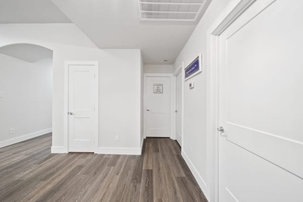 Interior hallway with white doors and wooden flooring