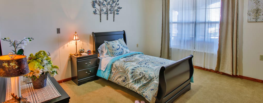 Brightly decorated resident bedroom with bedside table