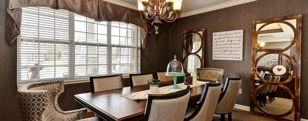 Dining area with a wooden table and decorative mirrors