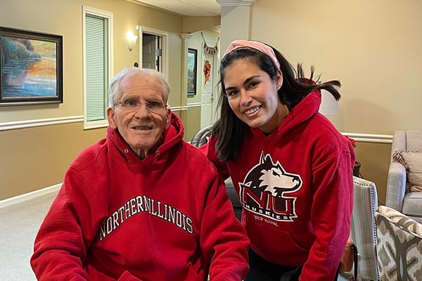 Resident and staff member posing together in a common area