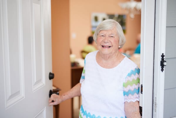 A smiling resident standing at the doorway