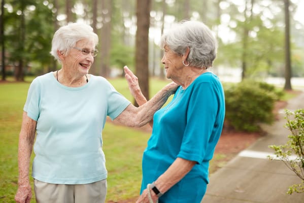 Two residents chatting in a garden area