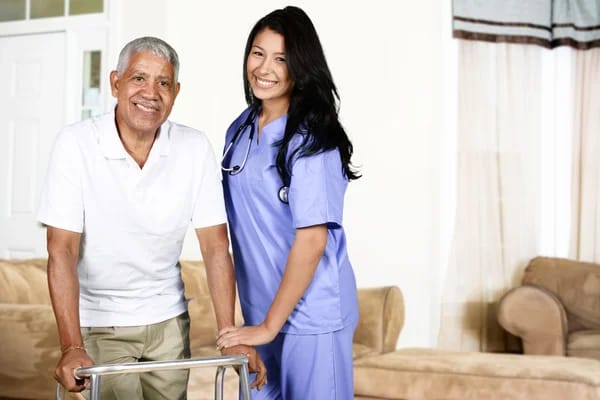 A caregiver and a resident smiling together in a facility.