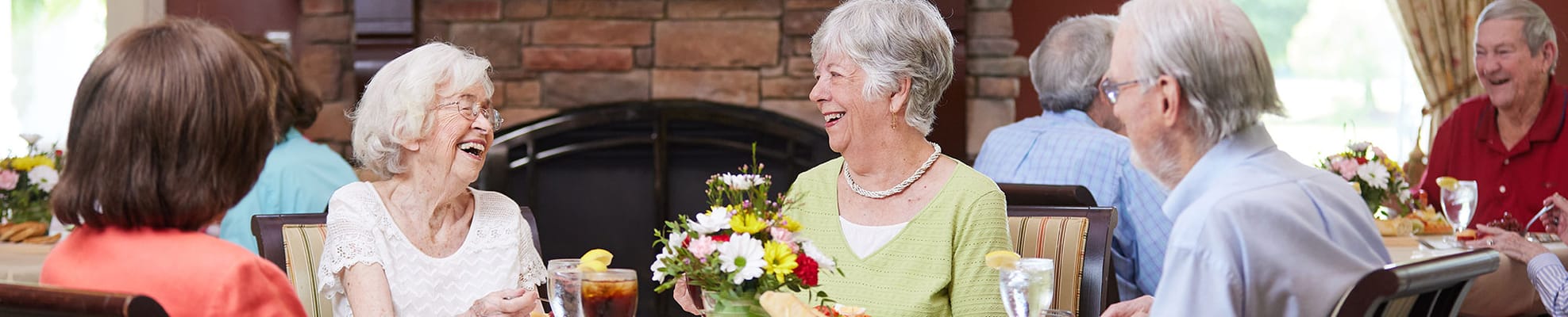 Residents enjoying a meal and conversation in a dining area