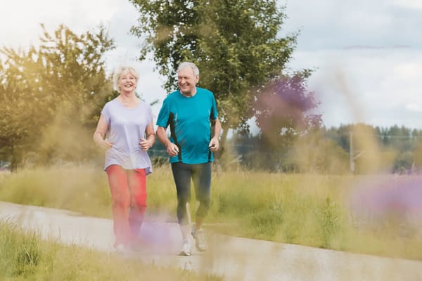 Senior couple jogging along a scenic pathway