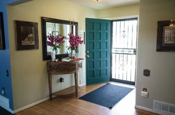 Entrance area of Assured Serenity 21 with a blue door and floral decor