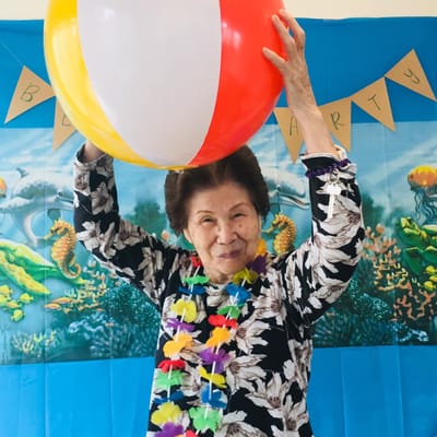 Resident enjoying a beach party with a beach ball