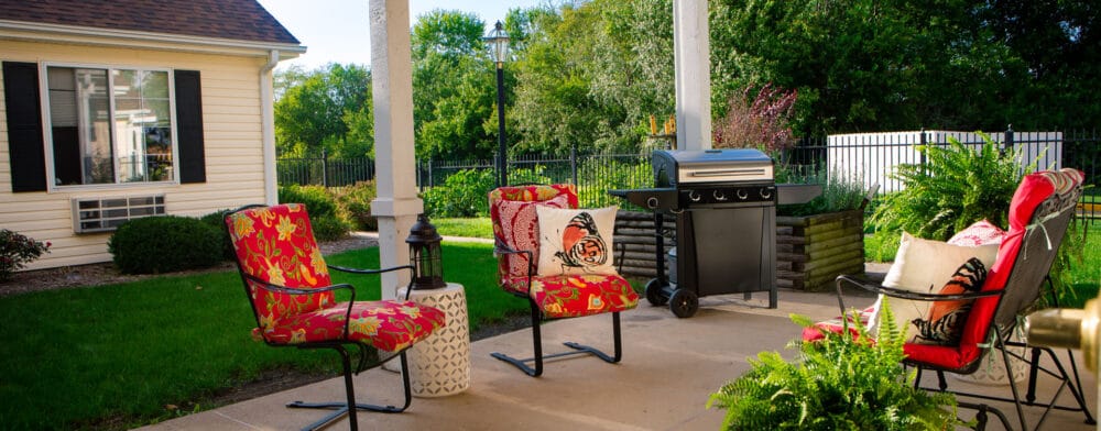 Outdoor seating area with grill and colorful chairs