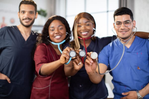 Healthcare staff smiling and holding stethoscopes