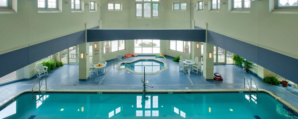 Indoor pool area with seating and natural light