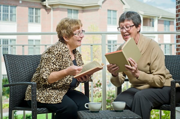 Two residents reading books on a balcony