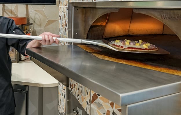 Chef preparing a pizza in the facility kitchen