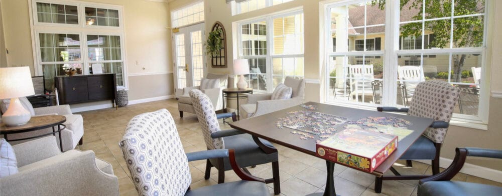 Bright common area with large windows and puzzle activity