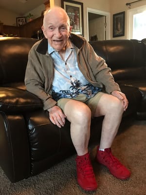 Senior resident sitting on a couch smiling