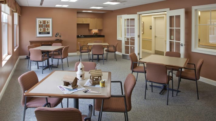 Bright common area with tables and chairs in the facility