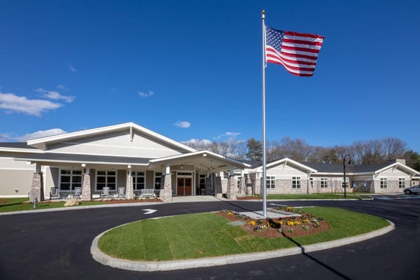 Exterior view of a senior living facility with flag