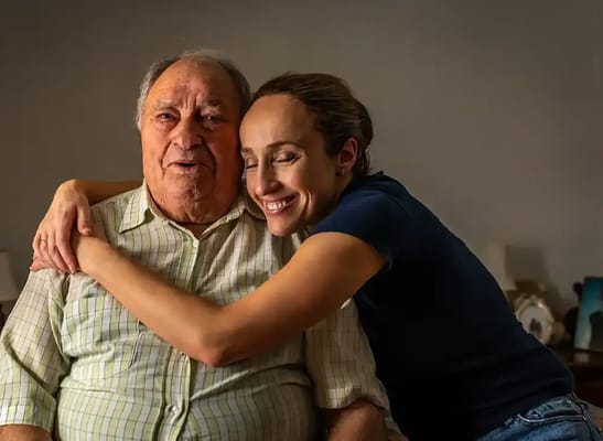 A senior man and caregiver sharing a joyful moment