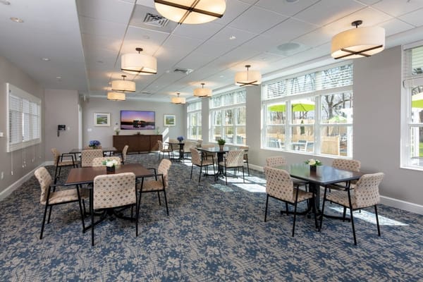 Bright common area with tables and chairs for residents