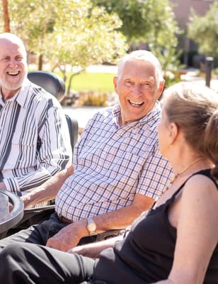 Residents enjoying conversation in a sunny outdoor space