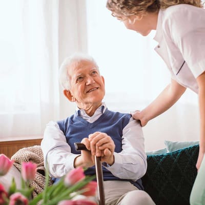 Resident engaging with staff in a cozy common area
