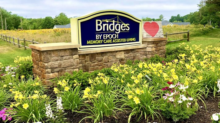 Facility sign surrounded by colorful flowers