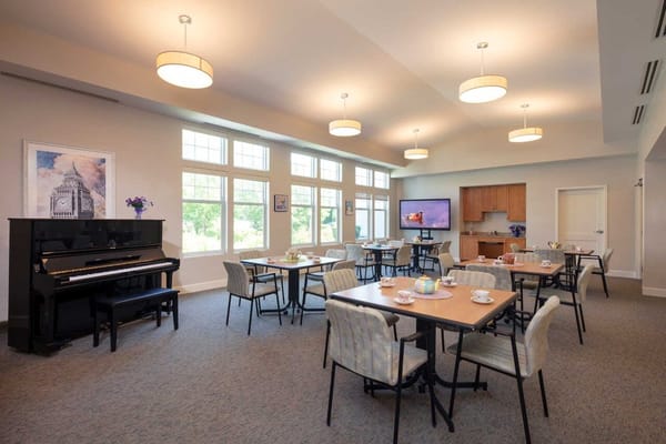 Bright common area with tables and a piano