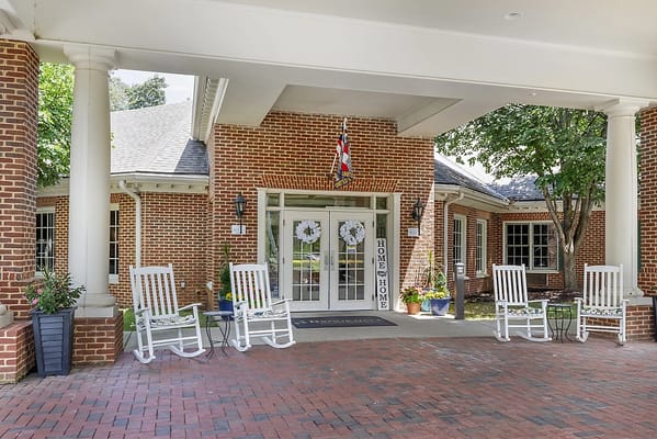 Entrance of a senior living facility with rocking chairs