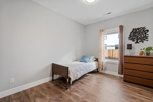 Bright private resident room with bed and window
