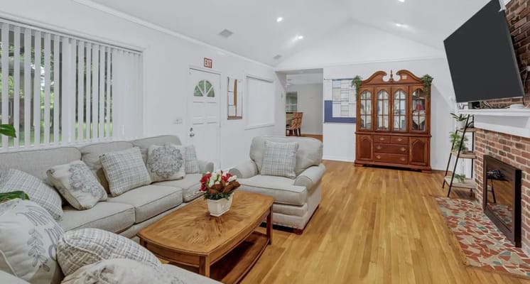 Bright common area with comfortable seating and wooden flooring