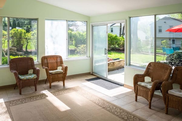 Bright sunroom with wicker chairs and view of garden