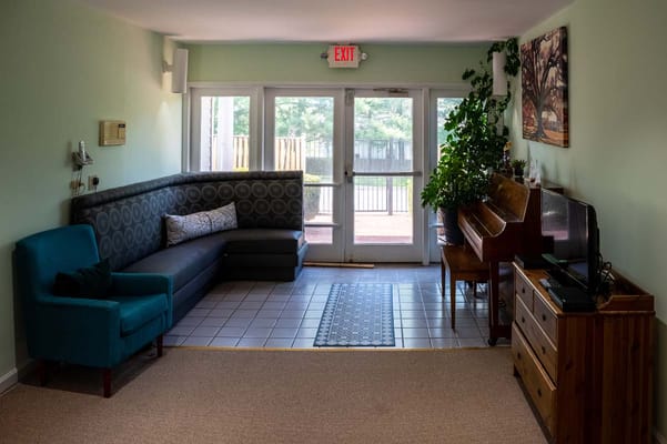 Bright common area with seating and a piano
