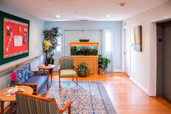 Bright common area with seating and fish tank