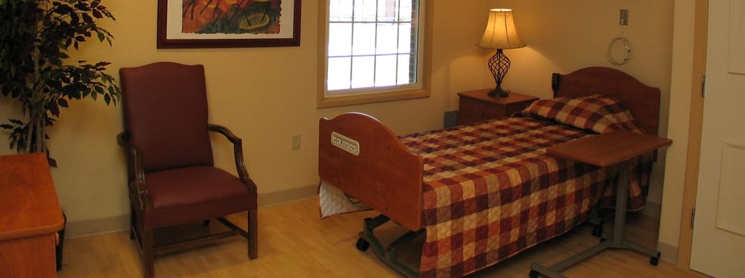 Interior view of a resident room with bed and chair
