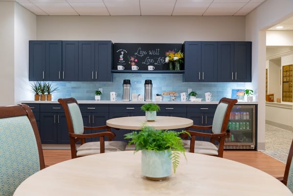 Bright interior lounge area with small tables and plants