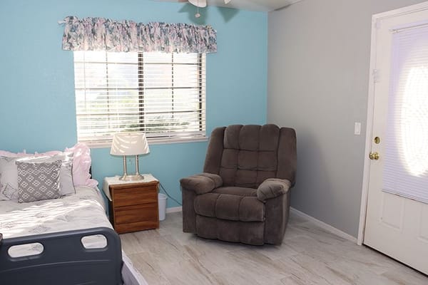 Cozy interior of a resident room with chair and bed