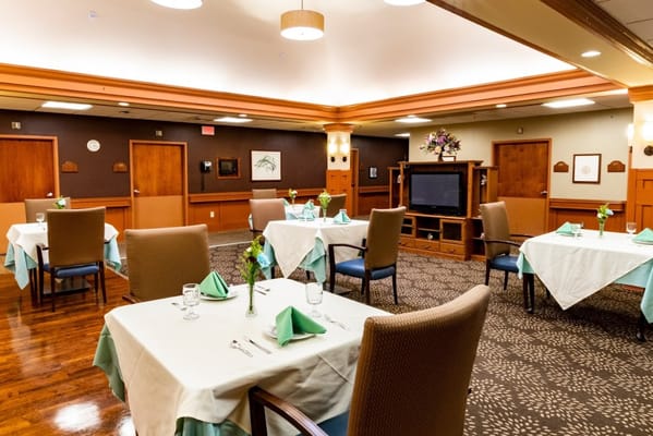 Dining room set up for a meal with tables and chairs