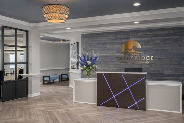 Modern reception desk with floral arrangement at Caley Ridge Assisted Living.