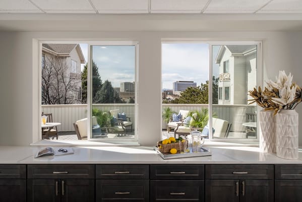 View from interior window showing outdoor seating area with decorative plants.